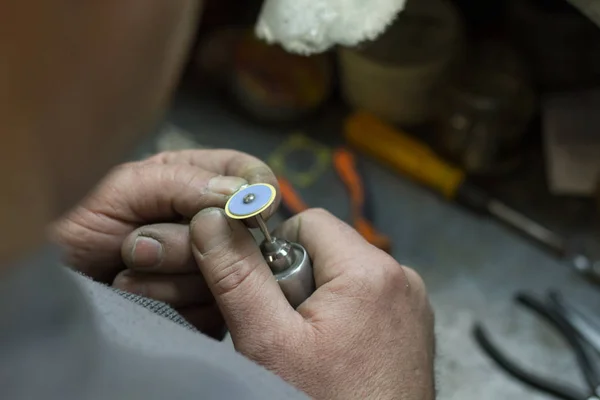Mistrz Jubiler trzyma narzędzie pracy w dłoniach i czyni biżuterię w swoim miejscu pracy — Zdjęcie stockowe