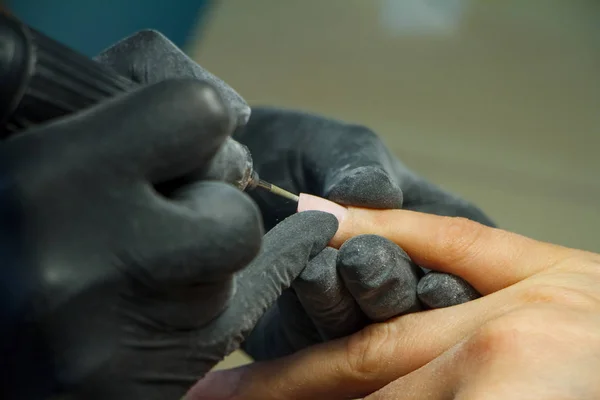 Manicure proces zbliżenie z maszyną do polerowania paznokci. Sprzęt manicure w nowoczesnym salonie piękności. — Zdjęcie stockowe
