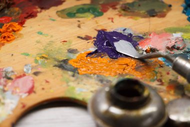 Beyaz yüzeyde renkli boyalar ve spatula ile paletin kapatılması, arka plan