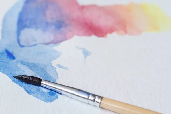 Close-up van prachtige aquarel penseelstreken op een wit blad, een penseel in de afbeelding — Stockfoto
