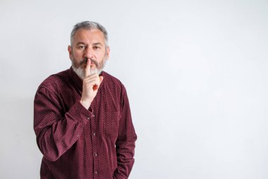 gray bearded man have the finger on lips as man gesturing shh sign, please be silent concept clipart