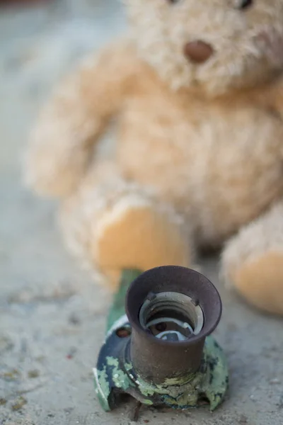 Teddy bear with a white ribbon thrown into the street in the fall in the rain — Stock Photo, Image