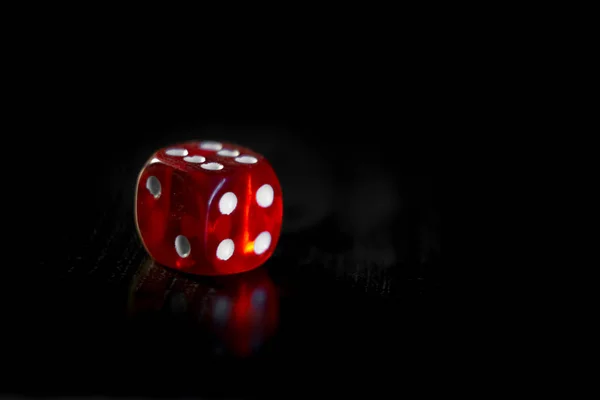 Closeup of a red dice with a winning number on the top face on a black mirror surface — Stock Photo, Image