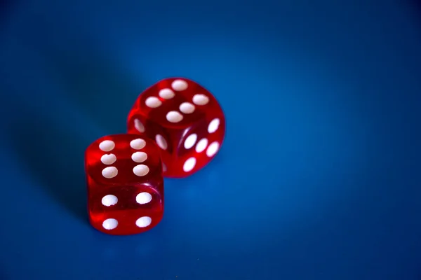 Close-up de dois dados vermelhos com seis no topo em um fundo azul — Fotografia de Stock