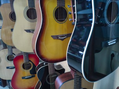 Bir müzik aleti mağazasında çeşitli akustik ahşap gitarların yakın çekim, arka plan veya müzik hakkında konsept