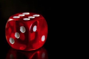 Siyah ayna yüzeyinde üst yüzünde kazanan bir sayı ile kırmızı zar yakın çekim