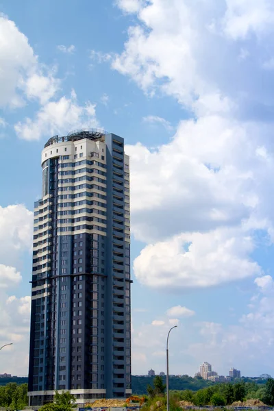 Modern skyscraper residential building and construction equipment over beautiful blue sky and clouds, selective focus — Stock Photo, Image