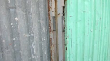 Yeşil ve gri kırık metal konstrüksiyon çiti boyunca hareket halindeki çerçeve, seçici odak