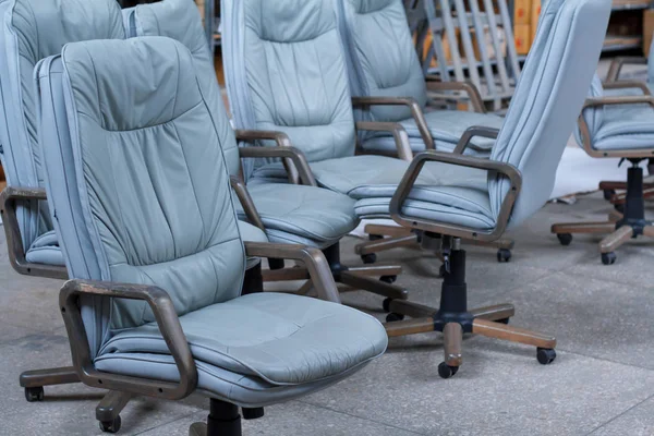 Varias sillas de oficina de cuero gris listas para envasar en un almacén de muebles, tienda de muebles en línea — Foto de Stock