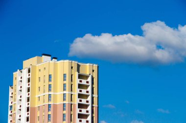 Arka planda mavi gökyüzü ve balkonları olan yeni apartmanlar.