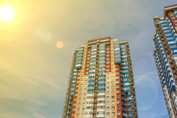 Dos nuevos bloques de apartamentos modernos con balcones sobre el cielo del atardecer en tonos naranja — Foto de Stock