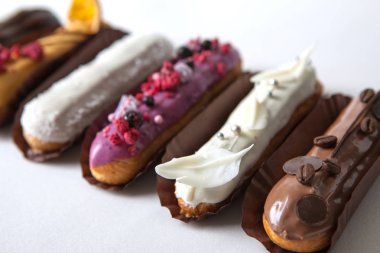 Çeşitli dolgular ve tasarım beyaz bir arka planda izole çeşitli Eclairs seti, Fransız mutfağı kavramı