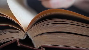Rusça bir kitap boyunca yapraklı bir adam elinin yakın çekim, sayfaların arasında parmaklarını çalıştıran, malzemeyi inceleyen, seçici odaklama