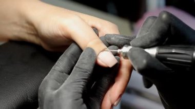 Güzellik uzmanı güzellik salonunda manikür yaptırmak için manikürcüyü öğütüyor. Tırnak tedavisi, öğütme ve cilalama. Manikürcü Eller Manikürcüde Kadın Manikürü Yapıyor.