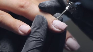 Güzellik uzmanı güzellik salonunda manikür yaptırmak için manikürcüyü öğütüyor. Tırnak tedavisi, öğütme ve cilalama. Manikürcü Eller Manikürcüde Kadın Manikürü Yapıyor.
