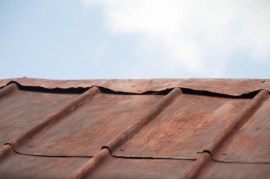 Mavi gökyüzüne karşı paslı oluklu metal çatı, yumuşak odak