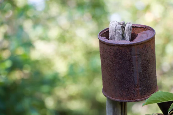 La lata oxidada puede colgar en una cerca de madera vieja sobre bosque empañado, foco selectivo — Foto de Stock