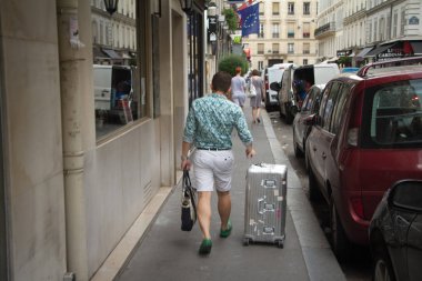 Farklı ulusların ve kıyafetlerin insanları Paris sokaklarında işleri için koşuşturur.