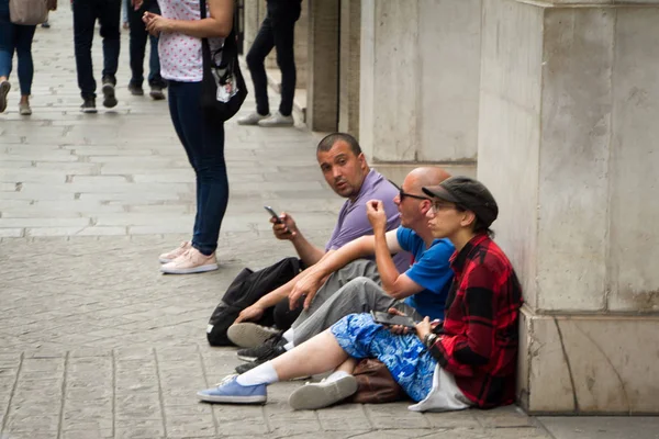 Várias pessoas sentam-se no passeio em Paris e conversam — Fotografia de Stock