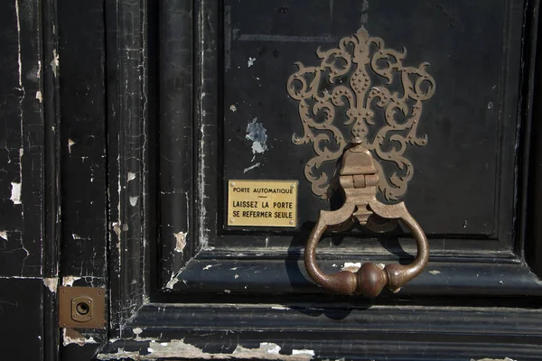 Close-up vintage black door with a copper handle beater and a sign with the address and name of the tenant on Place Vendome — Stock Photo, Image