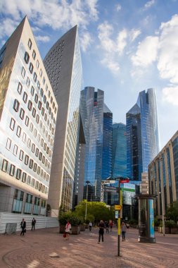 Birkaç kişi gün batımında Paris La Defense finans bölgesinde kendi iş hakkında gitmek ve gökdelenlerin alt görünümü