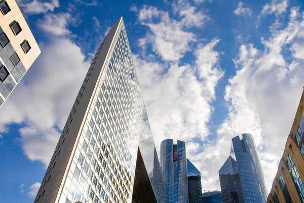 Vista inferior de los rascacielos de cristal del distrito financiero de París La Defense contra un cielo azul nublado — Foto de Stock