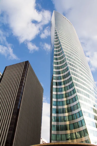 Vista inferior de los rascacielos de cristal del distrito financiero de París La Defense contra un cielo azul nublado — Foto de Stock