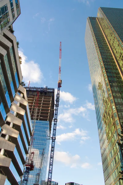 Grúa de construcción y un rascacielos en construcción contra el cielo azul en el distrito de La Defense en París — Foto de Stock