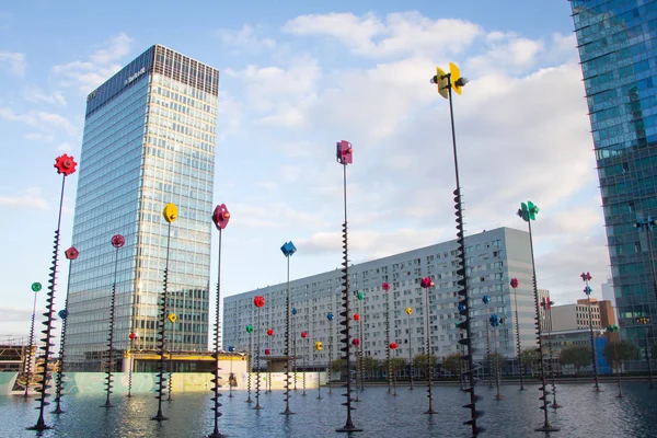 Fontein met kleurrijke windmolens en tafels aan de randen over de wolkenkrabbers bij de ingang van de metro in de zakenwijk van Paris La Defense — Stockfoto