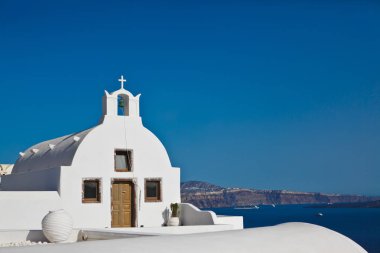 Santorini Adası düşük görünümde Oia mavi gökyüzü ile güneşli bir gün eski beyaz Ortodox kilise