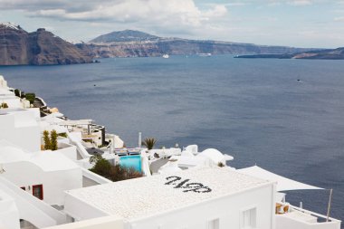 Santorini adasında Oia kasabasında Caldera üzerinde mavi kubbeler ile geleneksel beyaz evler ve kiliseler görünümü