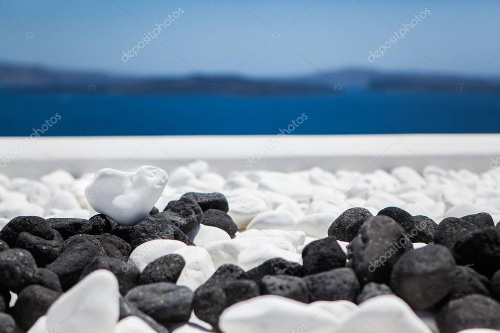 White stone heart shape on a background of blue sea and sky