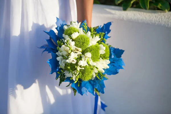 Noiva detém buquê de casamento em cores brancas e verdes e decoração azul . — Fotografia de Stock