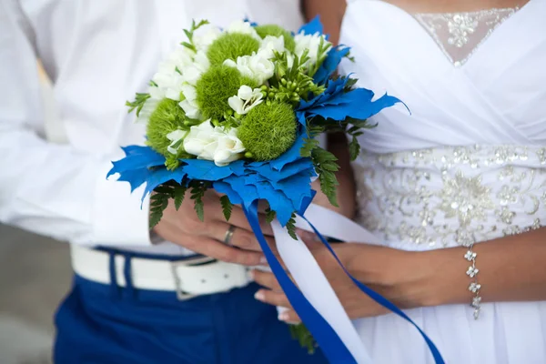 Новобрачные держат свадебный букет в белом и зеленом цветах и синем оформлении — стоковое фото