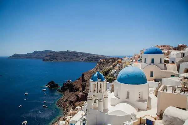 Santorini adasında Oia kasabası, Yunanistan. Caldera üzerinde mavi kubbeli geleneksel beyaz evler ve kiliselerin görünümü — Stok fotoğraf