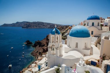 Santorini adasında Oia kasabası, Yunanistan. Caldera üzerinde mavi kubbeli geleneksel beyaz evler ve kiliselerin görünümü