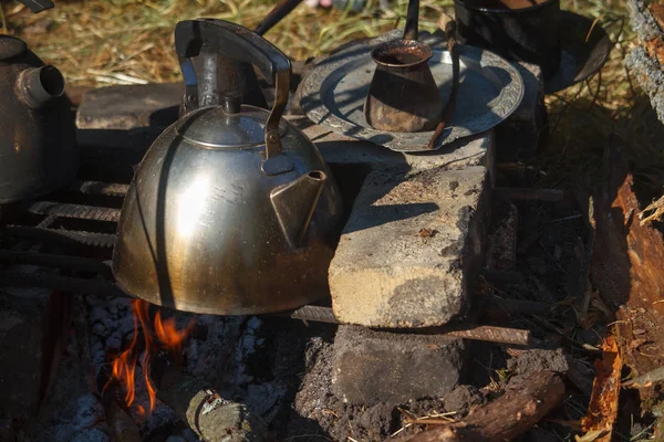 Yakın çekim füme metal su ısıtıcısı üzerinde bir ev yapımı fırında ateş ve cezva taze demlenmiş kahve ile — Stok fotoğraf
