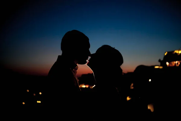 Zamilovaný pár se dívá na zapadajícího slunce na nejromantičtější ostrov na světě Santoríni — Stock fotografie