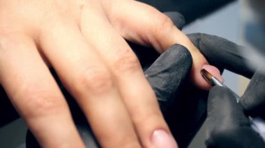 Sürecinde profesyonel çivi bakımı, siyah eldiven kozmetik polygel kapaklı bir manikür için çivi kadın müşteri yapma