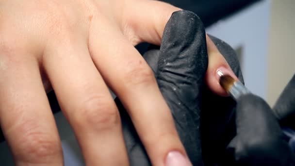 Профессиональный уход за ногтями в процессе, косметик в черных перчатках делает ногти женский клиент для маникюра с полигелевым покрытием — стоковое видео