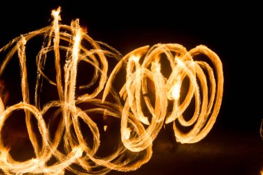 Sanatçı gece meşaleler dönen bir yangın gösterisi gösterir, ateş ve döngüler daireler