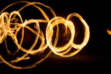 Sanatçı gece meşaleler dönen bir yangın gösterisi gösterir, ateş ve döngüler daireler