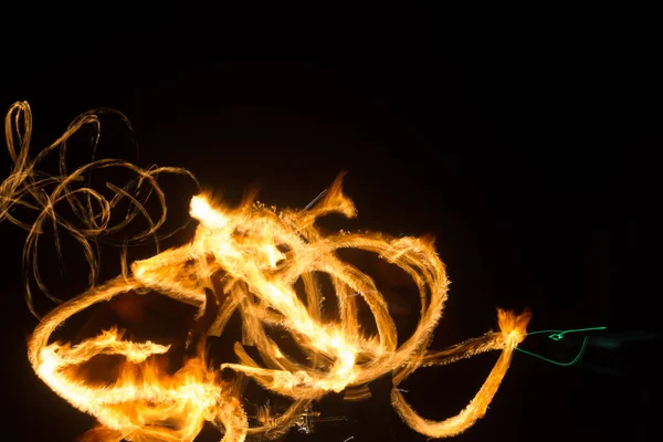 Der Künstler zeigt eine Feuershow bei Nacht, bei der Fackeln, Feuerkreise und Schleifen gesponnen werden — Stockfoto