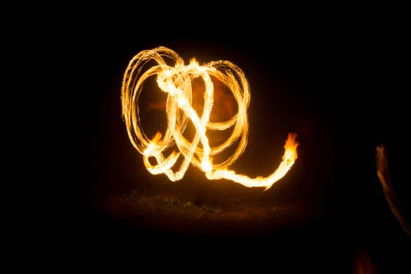 Ο καλλιτέχνης δείχνει ένα σόου πυρκαγιάς τη νύχτα περιστρεφόμενοι φακοί, κύκλοι φωτιάς και βρόχους — Φωτογραφία Αρχείου