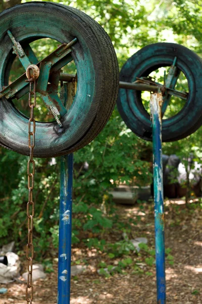 Gros plan d'un simulateur fait maison à partir de vieux pneus au milieu d'arbres épais dans un parc urbain, concept de mode de vie sain, mise au point sélective — Photo