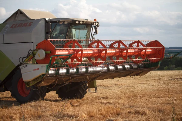 Menggabungkan pemanen dengan mekanisme yang dibesarkan menunggangi jerami setelah memanen ladang gandum untuk panen — Stok Foto