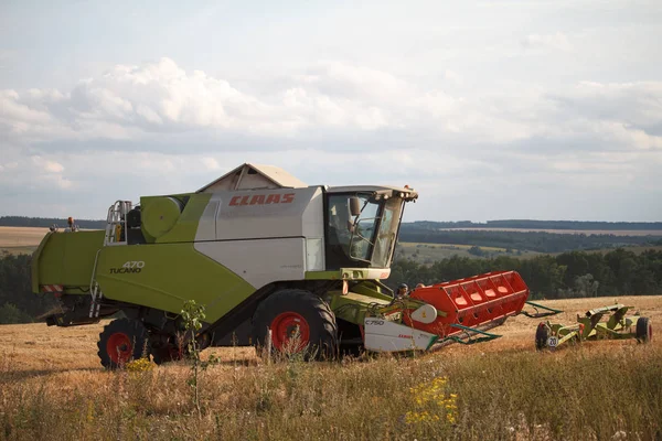 Menggabungkan pemanen dengan mekanisme yang dibesarkan menunggangi jerami setelah memanen ladang gandum untuk panen — Stok Foto