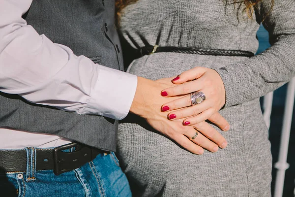 Mão masculina e feminina acariciando a barriga de uma mulher grávida, o conceito de espera para o nascimento da criança, foco seletivo — Fotografia de Stock