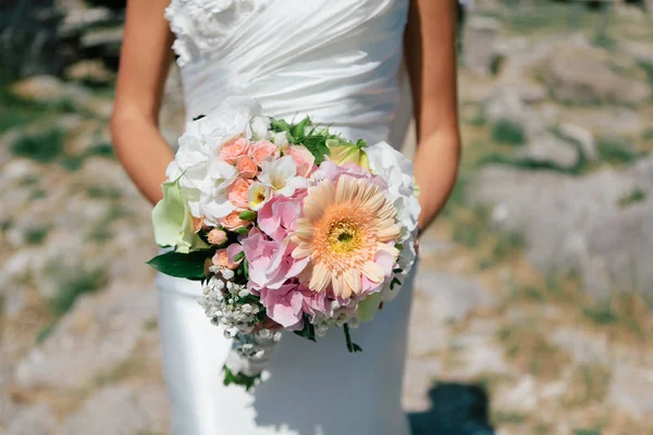 Η νύφη κρατά ένα μπουκέτο φρέσκο άνοιξη και το καλοκαίρι λουλούδια σε παστέλ χρώματα σε θολή φόντο, επιλεκτική εστίαση — Φωτογραφία Αρχείου