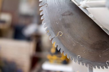 Yakın çekim sabit dairesel testere bir maranyesiz masasında bir marandülhane Atölyesi, seçici odak bulanık bir arka plan üzerinde